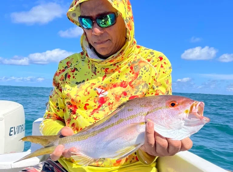 Pescador mostrando un huachinango recién pescado